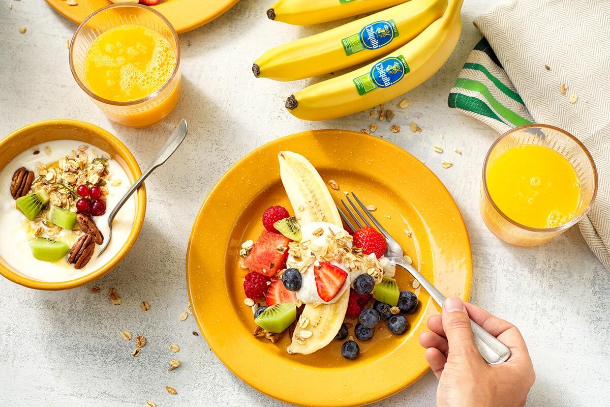 Gezonde fruitsalade met organische Chiquita-banaan en muesli-bananenyoghurt