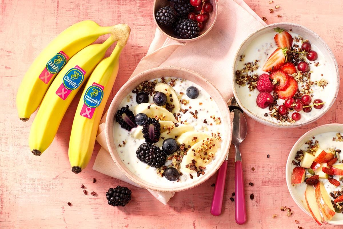 Gezond ontbijtkommetje met quinoa, Chiquita-banaan, magere Griekse yoghurt, appel, rood fruit en cacaokernen (cocoa nibs)