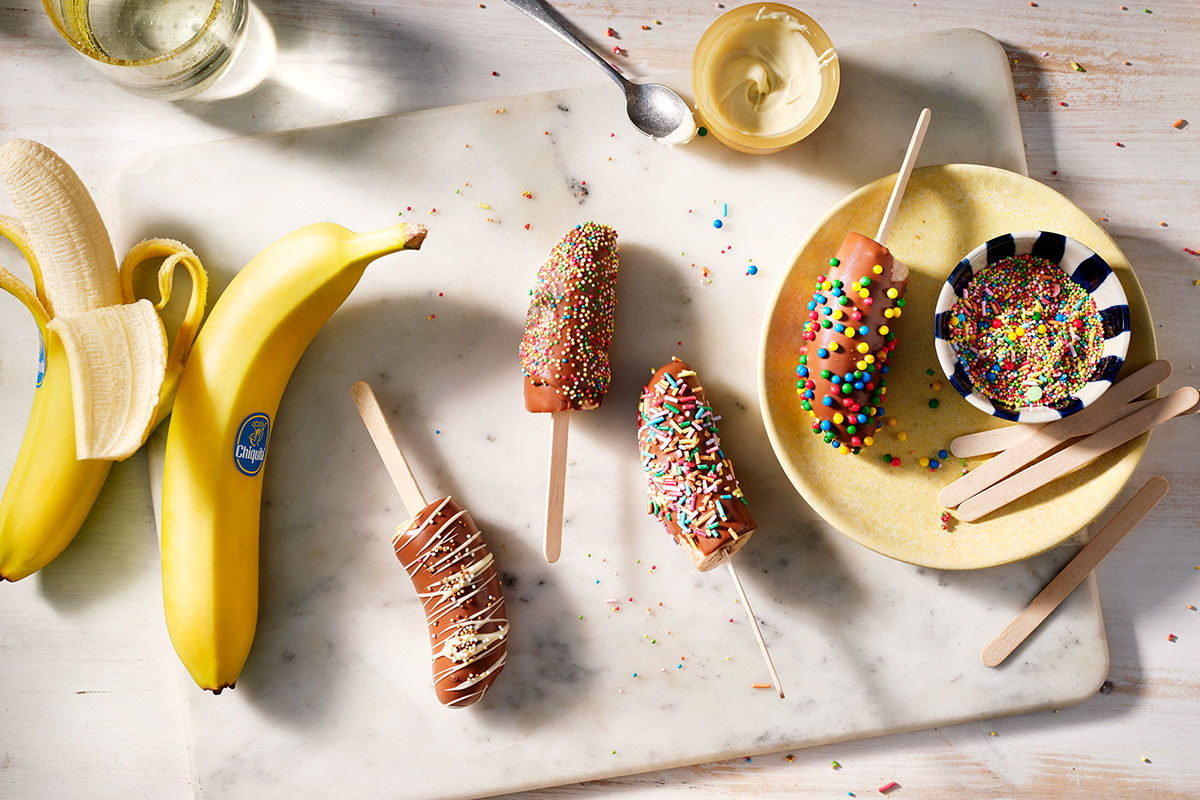 Bevroren bananenpops met een laagje chocolade en (gekleurde) hagelslag